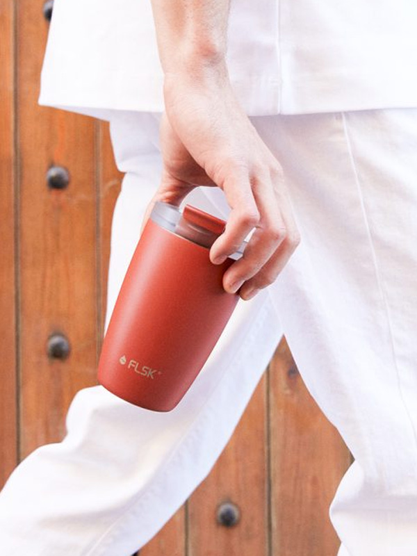 Individualisierter roter Kaffeebecher in der Hand – perfektes Werbemittel für unterwegs mit starkem Branding-Effekt